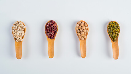 Mung beans, Red kidney beans, Chickpeas source and peeled barley isolated on spoon wooden on white background