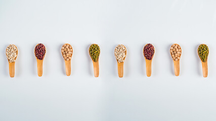 Mung beans, Red kidney beans, Chickpeas source and peeled barley isolated on spoon wooden on white background
