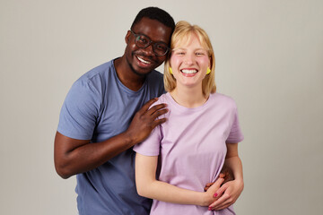 Portrait of happy multiracial couple embracing and smiling at camera