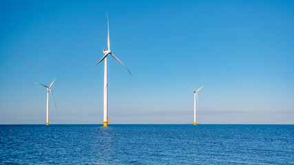 offshore windmill park with clouds and a blue sky, windmill park in the ocean aerial view with wind turbine Flevoland Netherlands Ijsselmeer. Green energy production in the Netherlands © Chirapriya