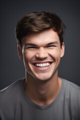 Obraz premium portrait of a handsome young man smiling against a gray background