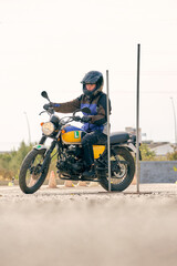 Fototapeta na wymiar Serious biker riding motorcycle on motordrome