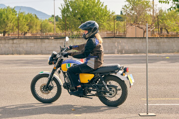 Fototapeta na wymiar Woman in helmet riding motorcycle on motordrome