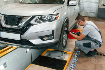Adjusting the tire. Man is works in the automobile repairing salon