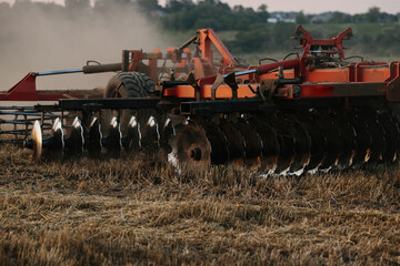 A tractor with a large disc harrow for tillage. Farmer work concept.