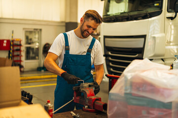 Portrait Shot of a Handsome Mechanic Working on a truck workshop Service. Professional Repairman....