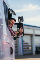 Truck driver sitting in his truck showing thumbs up. Trucker occupation. transportation services.