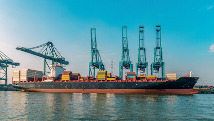 Antwerp, Belgium, view of harbor cranes and container ships in the largest dock of the port of Antwerp. Huge container vessel in the harbor with containers
