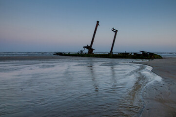 The remains of an old shipwreck on the beach at low tide
