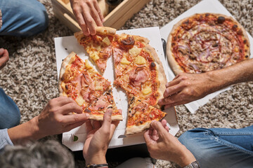 Crop unrecognizable men eating pizza at party