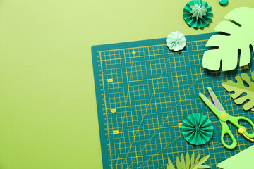 Concept of accessories for patchwork on a green background, mat cutting