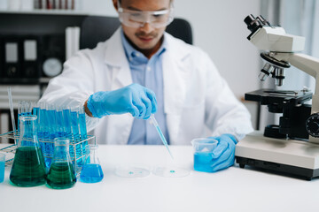 Fototapeta premium Scientist mixing chemical liquids in the chemistry lab. Researcher working in chemical laboratory.