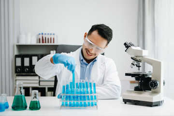 Modern medical research laboratory. male scientist working with micro pipettes analyzing biochemical samples, advanced science chemical laboratory medicine.