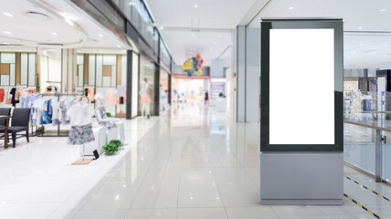 Blank billboard in a modern shopping center. Display for mock-up and advertising. Blackground with mannequins in fashion shop display window.
