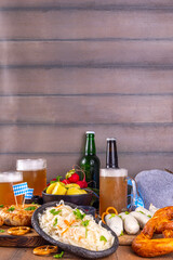 Oktoberfest munich traditional festival menu foods - bavarian sausages, pretzels, potato, sauerkraut, beer bottle and mug,  Background flyer for Oktoberfest invitation on old wooden table
