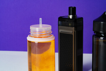 Electronic cigarettes liquid bottles on purple background