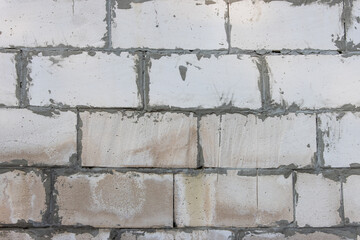 Close-up of a sloppy and incorrectly built wall of a house made of cellular blocks