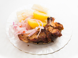 Dish of fried pork ribs, rice, potatoes, sweet potato and pickled onions