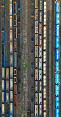 Obraz premium Drone view of freight trains. Colorful railway cargo wagons on railroad. Aerial view of colorful wagons. Depot of freight trains. Railway station. Transportation and Industry.