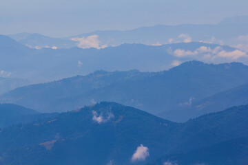 Fototapeta na wymiar mountain ridge silhouette in blue mist, early morning mountain background