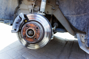 Old car brake disc. Technical inspection of the running gear and replacement of spare parts. Close-up. selective focus