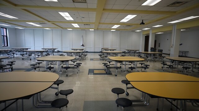 Empty school cafeteria with tables and seats.