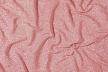 Fototapeta na wymiar Sparkling fabric for party dresses slightly crumpled, dusty rose pink background, disco nostalgia.