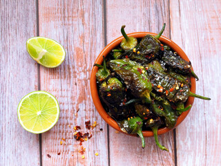 Roasted Padron Peppers in Ceramic Bowl with Lime Slices