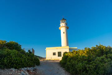 Detail of the white lighthouse or Cape Ducato Lefkas at sunset in the southern area of the island of Lefkada. Greece.
