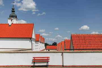 white walls and red tile roofs of camaldolese monk's houses in Wigry village, Poland
