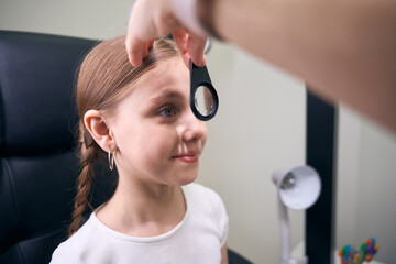 Doctor in the clinic checks the eyesight of young patient