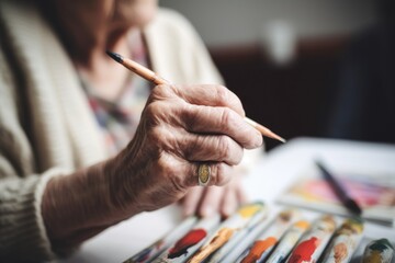 shot of a woman using paintbrushes during an art therapy session