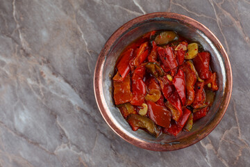 Red pepper with olive oil appetizer in a bronze bowl 