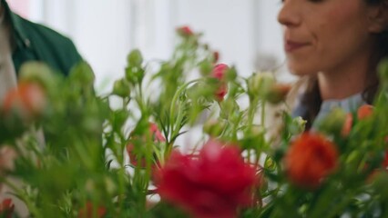 Married couple enjoy roses flowers in florist store. Two lovers buy bouquet.