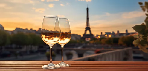 Rolgordijnen Two Glasses of wine on Wooden table top table. night view of the Eiffel Tower blurred on the background. Paris, vacation concept for mounting your product. © IgnacioJulian