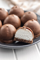 Chocolate covered marshmallows. Sweet dessert on plate.