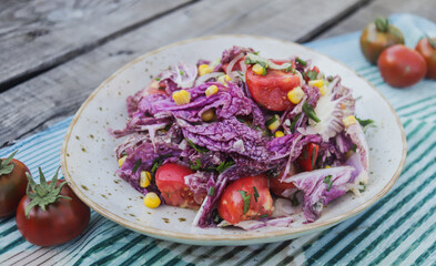 fresh salad of tomatoes and purple chinese cabbage in a clay plate close-up selective focus