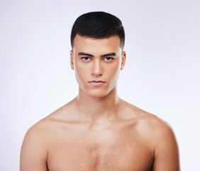 Fototapeta premium Serious man, portrait and skincare in grooming, hygiene or natural beauty against a white studio background. Attractive or handsome male person or model looking in pose isolated on mockup space