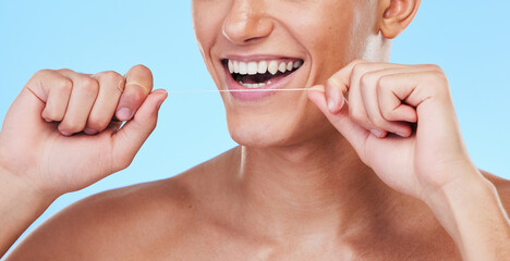 Happy man, dental floss and cleaning teeth in oral hygiene or grooming against a blue studio...