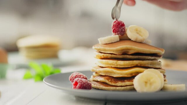 Sweet, pregnant worker confidently cooking American pancakes at home kitchen. Close up young parent cooking pancakes for breakfast use new morning breakfast recipe, dessert