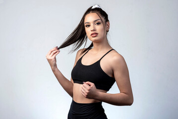 young latin woman wearing sportswear doing figure poses and gestures happy on white background