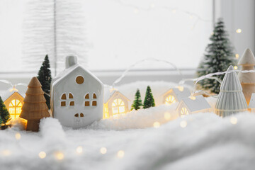 Atmospheric miniature winter village. Stylish cute little ceramic houses and christmas wooden trees...