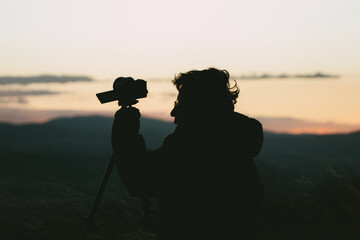 Photo of silhouette of photographer at a sunset in the mountains of Peru. Concept of travel, nature and people.