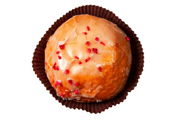 A berliner donut with shiny icing and red fruit sprinkled on top in a decorative mould seen on a...