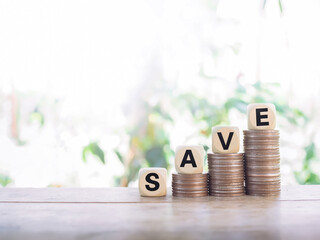 Wooden blocks with the word SAVE on stack of coins, The concept of save money for prepare in the future.