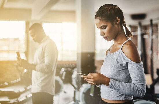 Fitness, gym and woman with a phone for communication, internet and workout app. Serious athlete person with a smartphone for texting, influencer post or online for wellness and health space or flare
