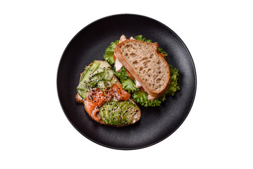 Fresh tasty sandwich with salmon, avocado and sesame and flax seeds