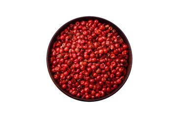 Spice, allspice peas of red or pink color in a wooden bowl