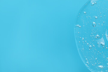 Sample of cleansing gel on light blue background, top view with space for text. Cosmetic product
