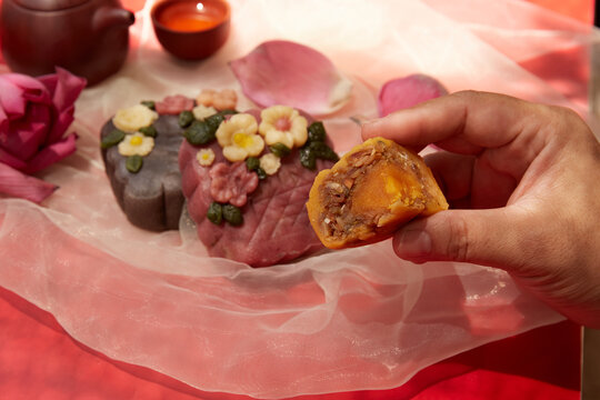 Female hand holding a tray of moon cakes in the garden on a sunny day